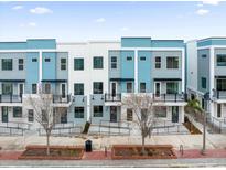 Modern townhome exterior with blue and gray accents, balconies, and landscaped front walkways at 879 City Walk Ln, Oviedo, FL 32765