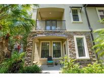 Charming home features stone accents, a balcony, and lush landscaping around the entrance for added curb appeal at 1327 Shinnecock Hills Dr, Davenport, FL 33896