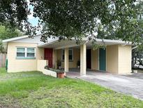 Charming single-story home featuring a covered carport, well-maintained lawn, and mature trees at 1400 Yates St, Orlando, FL 32804