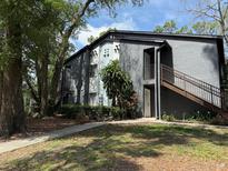 Condo exterior features include stairs, landscaped grounds, and ample trees at 190 Riverbend Dr # 102, Altamonte Springs, FL 32714