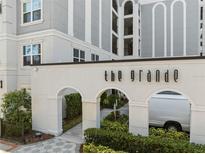 Beautiful building entrance to The Grande, featuring arched entryways and lush landscaping at 206 E South St # 6007, Orlando, FL 32801
