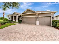 Charming single-story home with a paved driveway and three-car garage at 2681 Cabernet Cir, Ocoee, FL 34761