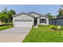Charming single-story home with a well-maintained lawn, gray siding and a two-car garage at 3678 Rollin O Ln, Apopka, FL 32703
