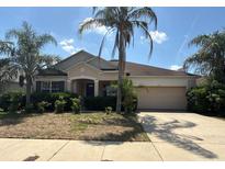 Charming single-story home featuring a lush front yard with mature palm trees and a two-car garage at 579 Setting Sun Dr, Winter Garden, FL 34787