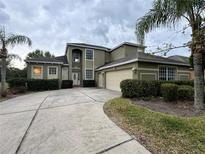 Two-story home featuring a long driveway, well-manicured landscaping, and an attached two-car garage at 6224 Zane Dr, Mount Dora, FL 32757