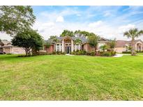 Beautiful single-story home with a sprawling green lawn and mature landscaping at 8704 Ingleton Ct, Orlando, FL 32836