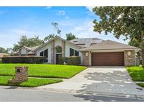 Charming single-story home with a well-manicured lawn, solar panels, and an attached two-car garage at 9774 Bohart Ct, Orlando, FL 32836