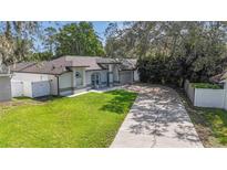 Charming single-story home featuring a well-manicured lawn, concrete driveway, and lush landscaping at 1008 Jackson Creek Ct, Oviedo, FL 32765