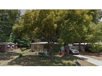 Modest house exterior with a car parked on the driveway and large trees at 134 Flamingo Dr, Auburndale, FL 33823