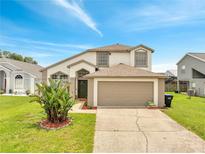 Charming two-story home featuring an attached two-car garage and well-manicured lawn and landscaped yard at 13404 Bradwater Ct, Orlando, FL 32828