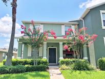 Charming two-story home with a landscaped yard, flowering trees, and inviting front porch at 15483 Avenue Of The Arbors, Winter Garden, FL 34787