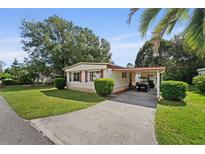 Well-maintained home featuring a carport, manicured lawn, and mature landscaping, offering great curb appeal at 2060 Lamplight Cir, Mount Dora, FL 32757