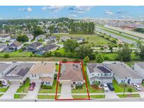 Aerial view of a home in a residential area highlighting solar panels on the roof at 245 Bella Verano Way, Davenport, FL 33897