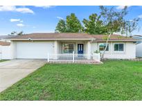 Well-maintained single-Gathering home features a manicured lawn, white picket fence, and blue front door at 2871 Milstead St, Orlando, FL 32837