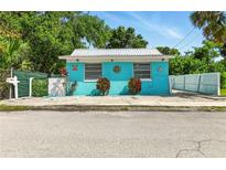 Charming bright blue single-story home with a metal roof and decorative accents at 318 Palm St, New Smyrna Beach, FL 32168