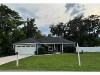 Charming home with a well-manicured lawn, lush landscaping, and a two-car garage at 358 2Nd St, Geneva, FL 32732