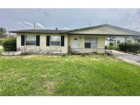 Modest single-story home featuring a covered front porch and a simple, grassy yard at 4402 King Cole Blvd, Orlando, FL 32811