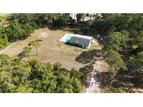 Expansive aerial view showcasing a secluded home with a pool and lush, mature landscaping at 4760 Ohio Ave, Sanford, FL 32771