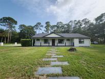 Charming single-story home with a welcoming front porch and stepping stone path leading to the entrance at 4760 Ohio Ave, Sanford, FL 32771