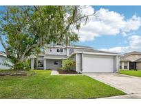 Charming two-story home with landscaped yard and attached two-car garage at 478 Chicago Woods Cir, Orlando, FL 32824