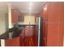 Well-lit kitchen features stainless steel appliances and dark countertops at 4830 S Conway Rd # 40, Orlando, FL 32812