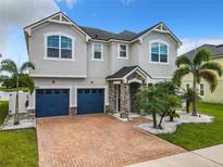 Charming two-story home featuring a brick driveway and lush landscaping with palm trees, perfect for Florida living at 4993 Southlawn Ave, Orlando, FL 32811