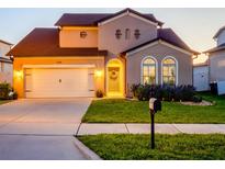 Charming two-story home featuring an attached garage, arched windows, and well-maintained landscaping at 5018 Tupelo Ct, Minneola, FL 34715