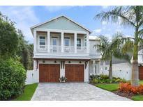 Beautiful two-story home featuring a spacious front porch and a well-manicured lawn with lush landscaping and a paved driveway at 507 S Pine St, New Smyrna Beach, FL 32169