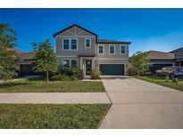 Charming two-story home with well-maintained lawn, lush landscaping, and a driveway leading to a two-car garage at 9199 Waverly Walk Dr, Orlando, FL 32817