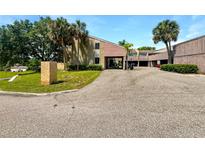 Exterior view of townhome featuring lush landscaping, palm trees, and covered parking at 1404 Oak Pl # A, Apopka, FL 32712