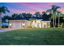 Inviting home featuring a lush lawn, well-manicured landscaping, and a side-entry two-car garage at 1907 Sir Lancelot Cir, St Cloud, FL 34772