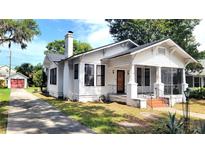 Charming white two-story house featuring a screened-in porch, chimney and mature landscaping at 206 N Highland Ave, Winter Garden, FL 34787