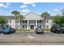 The property boasts a well-maintained exterior with a light gray brick facade and lush landscaping at 225 Lewfield Cir # 225, Winter Park, FL 32792