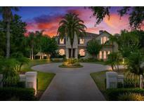 Stately home boasts a circular driveway, lush landscaping, and timeless architectural details at 2357 Alaqua Dr, Longwood, FL 32779