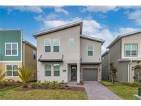 Modern two-story home with a combination of stucco, stone, and brick exterior and landscaped front yard at 3004 Protagonist St, Kissimmee, FL 34746