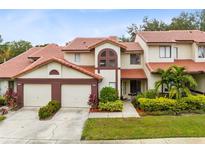 Inviting two-story home featuring a red tile roof, two-car garage, and beautifully landscaped front yard at 3336 Gray Fox Cv # 3336, Apopka, FL 32703