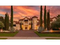 Stunning home with mature landscaping, elegant architectural details and a dramatic sunset backdrop at 3521 Legacy Hills Ct, Longwood, FL 32779