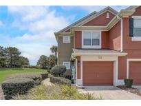Two-story townhouse with a one-car garage and a well-maintained landscaped yard with lawn at 4178 Sw 43Rd Cir, Ocala, FL 34474