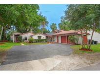 A single Gathering house with a red-tiled roof has a driveway, landscaping, and a two-car garage at 4420 Conway Gardens Rd, Orlando, FL 32806