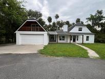 Charming exterior showcasing white painted home with garage and inviting yard at 470 Sunset Rd, Deltona, FL 32725