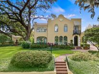 Stunning two-story home featuring lush landscaping, a brick pathway, and distinctive architectural details at 522 Cherokee Dr, Orlando, FL 32801