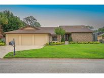 Charming single-story home featuring a three-car garage and lush, green lawn at 6766 Edgeworth Dr, Orlando, FL 32819