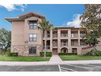 Attractive apartment building with stone accents, balconies and a well-maintained lawn at 909 Charo Pkwy # 1011, Davenport, FL 33897