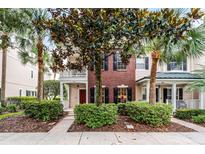 Charming brick townhome with a cozy front porch and lush landscaping provides inviting curb appeal at 9670 Cypress Pine St, Orlando, FL 32827