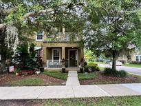 Charming two-story home with a front porch, balcony and lush landscaping creating a welcoming curb appeal at 10350 Lake District Ln # S, Orlando, FL 32832