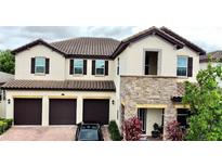 Charming two-story home features a three-car garage and stone accents, situated on a nicely landscaped lot at 16611 Toccoa Row, Winter Garden, FL 34787