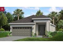 Beautiful single-story home showcasing lush landscaping, a neutral color palette, and an attached two-car garage at 180 Duckweed Ave, Fruitland Park, FL 34731