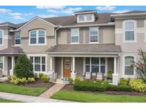 Charming two-story home with a covered front porch, well-maintained landscaping, and neutral-toned exterior at 2696 Giardino Loop, Kissimmee, FL 34741