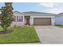 Charming single-story home with a well-manicured lawn and inviting curb appeal at 394 Quayside Ave, Mascotte, FL 34753