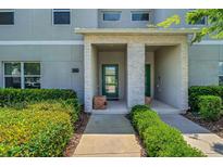 Inviting townhouse entrance featuring a green door and manicured landscaping at 424 Ocean Course Ave, Davenport, FL 33896